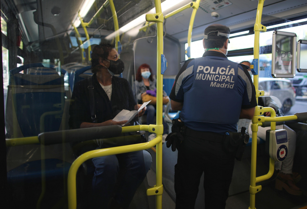 Un agente de la Policía Municipal de Madrid realiza un control de movilidad en una línea de autobús que pasar por el distrito de Puente de Vallecas, Madrid.