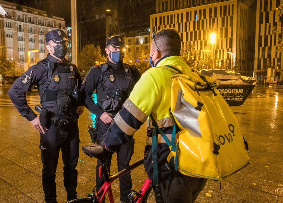 Unos policías informan en Zaragoza a un repartidor sobre la aplicación del toque de queda desde las 23.00 a las 06.00 horas