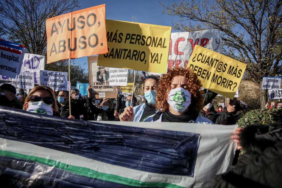Varias personas se manifiestan con pancartas durante una concentración convocada por la plataforma Sanitarios Necesarios en la puerta del Hospital Enfermera Isabel Zendal.