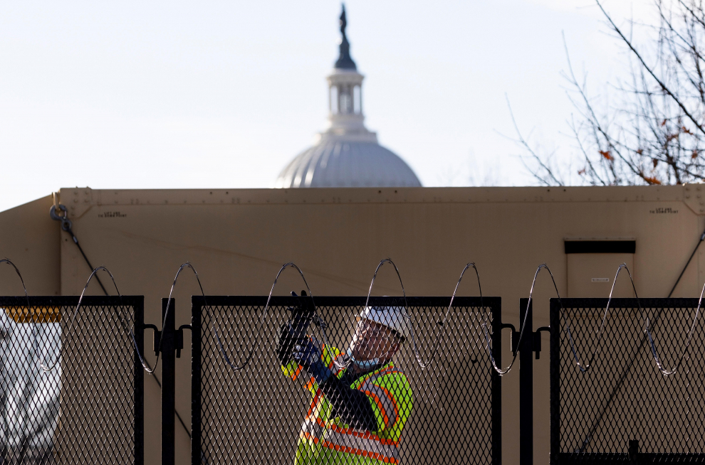 Un trabajador agrega más alambre de púas en la valla alrededor del edificio del Capitolio de Estados Unidos en Washington.