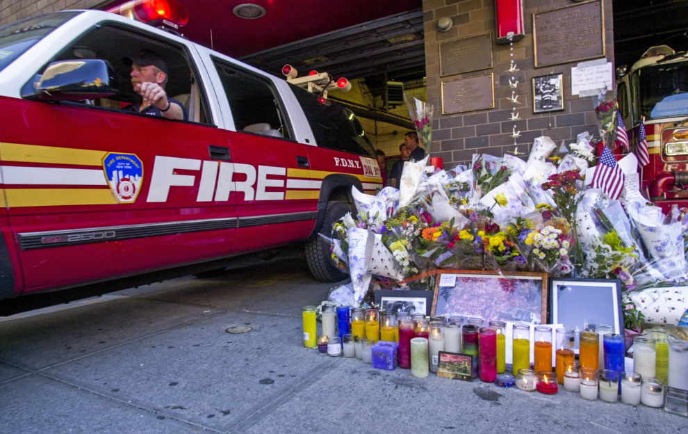 Un memorial de flores, velas y una bandera estadounidense a las puertas de una estación de bomberos de Nueva York que perdió a 15 bomberos tras el ataque al World Trade Center.