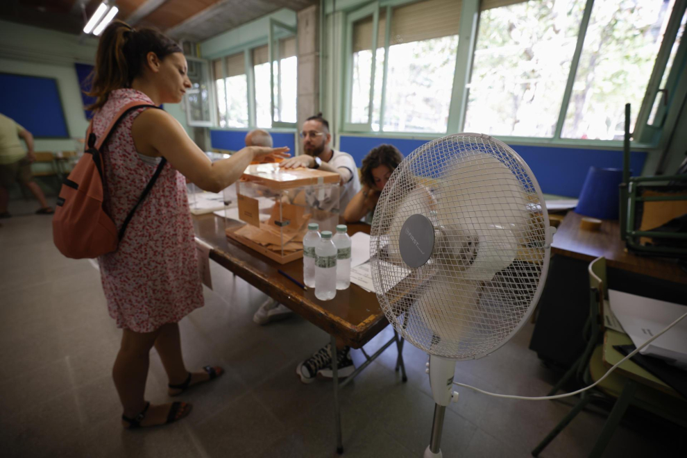 na mujer ejerce su derecho al voto en una mesa electoral en la Escuela Mercè Rodoreda en Badalona, este domingo. Junto a las urnas, un ventilador, protagonista indiscutible de esta jornada electoral.