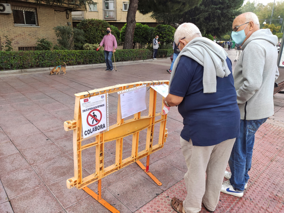 Un hombre toca un cartel para leer las medidas adoptadas frente al coronavirus este lunes en Alcobendas.