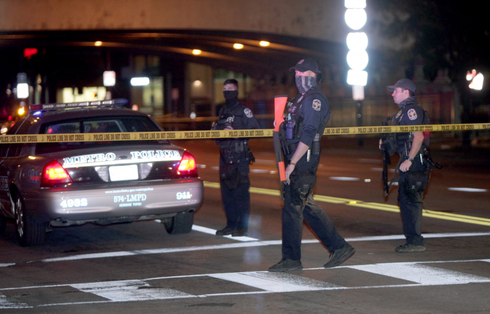Agentes de la Policía Metropolitana de Louisville custodian la escena del crimen en Broadway después de que dos compañeros fueran baleados en Louisville, Kentucky.