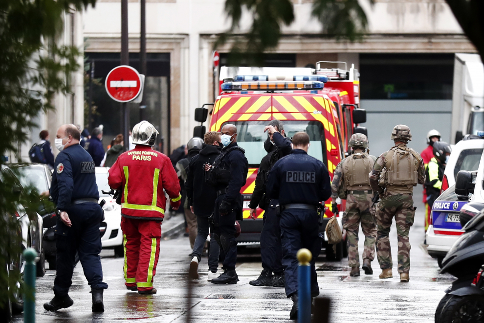 Las fuerzas de seguridad francesas caminan en la Rue Nicolas Appert cerca de las antiguas oficinas de Charlie Hebdo.