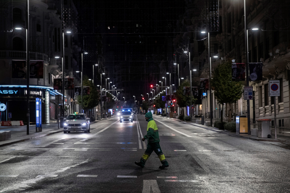Un operario de los servicios de limpieza cruza la Gran Vía anoche, en la primera jornada de toque de queda en la capital.