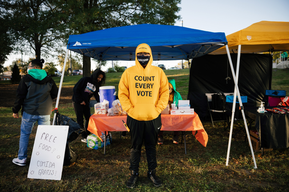Voluntarios reparten alimentos y bebidas gratis a los votantes fuera de la biblioteca del condado de Durham en Durham, Carolina del Norte.