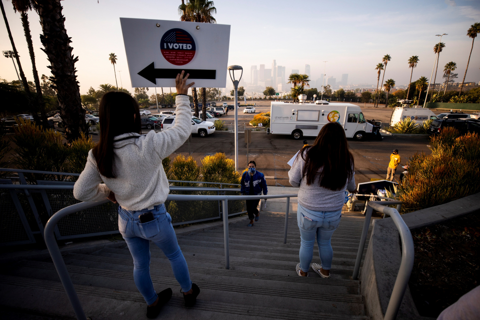 Los trabajadores electorales saludan a un votante a su llegada al Dodger Stadium en Los Ángeles, California.