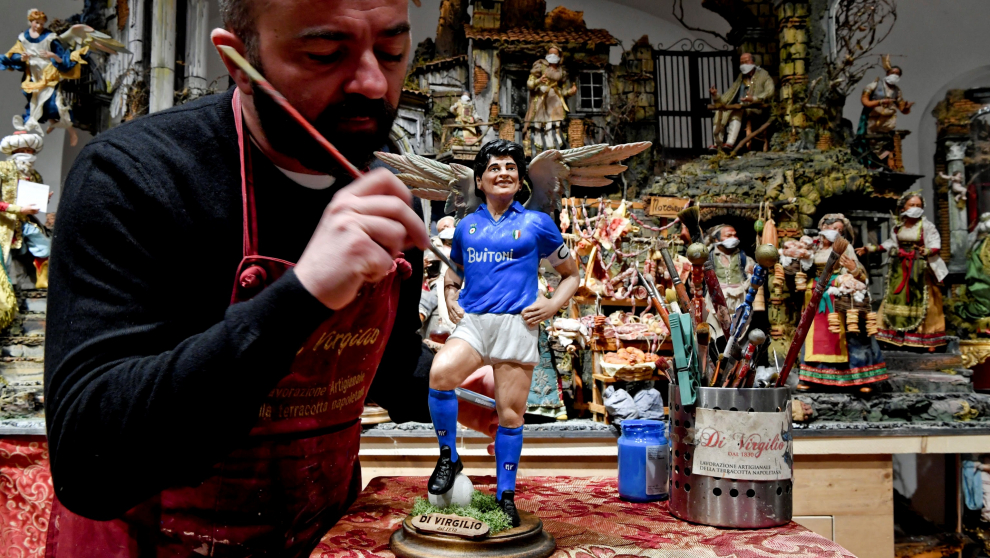 El artista italiano, Genny Di Virgilio, retoca una figura de Maradona que aparecerá en el tradicional Presepio napolitano en Nápoles, Italia.