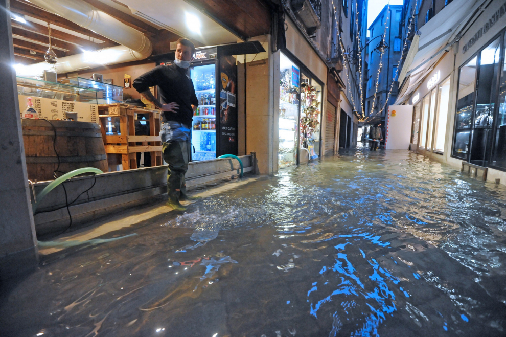 Un comerciante observa la subida del agua en la ciudad.