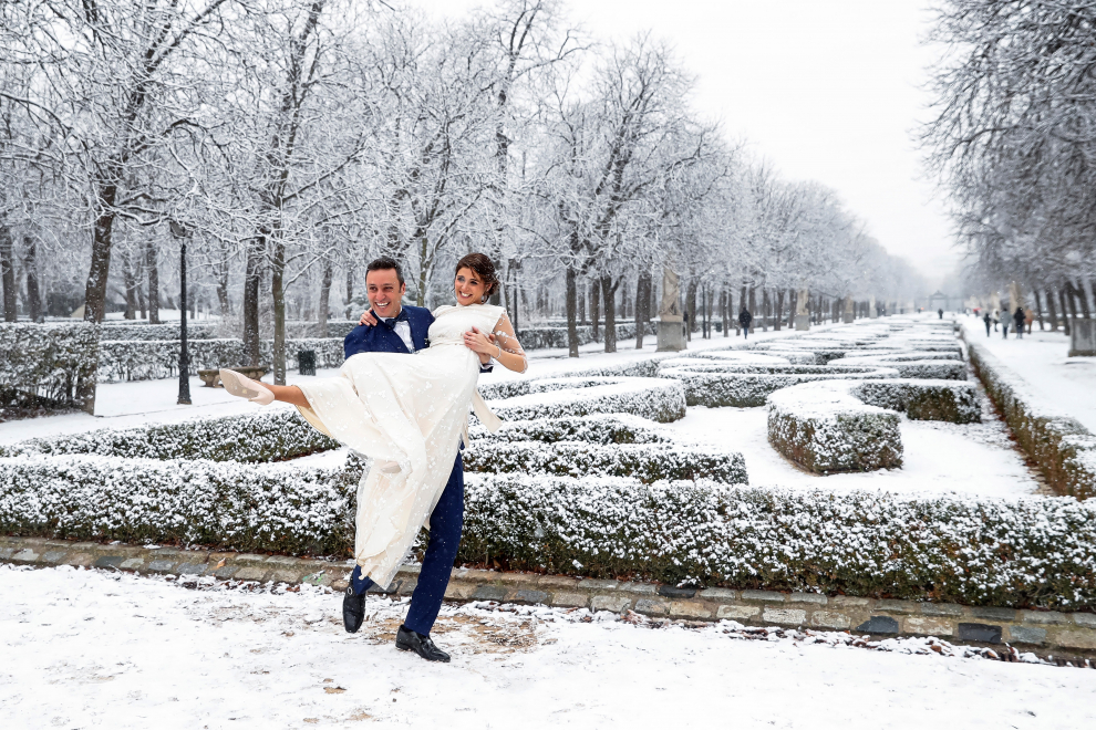 Los recién casados Julio y Yone posan en el parque del Retiro durante la nevada de este jueves en Madrid.