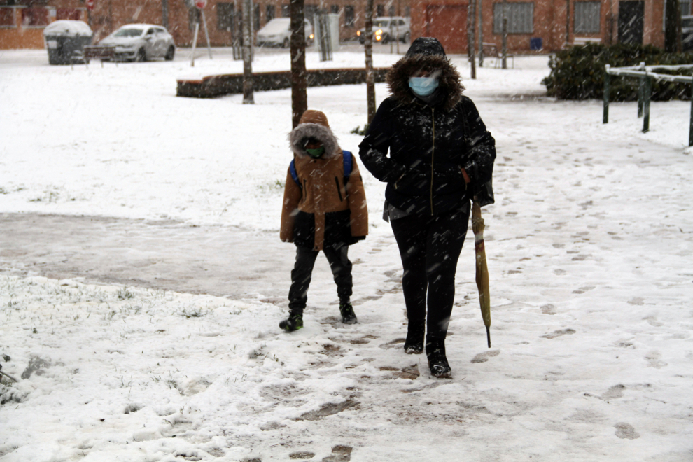 Una mujer y un niño caminan por una calle nevada este jueves en Ciudad Real.