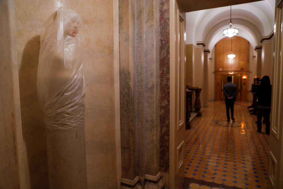 Una estatua destrozada cubierta de plástico dentro del Capitolio de los Estados Unidos en Washington.