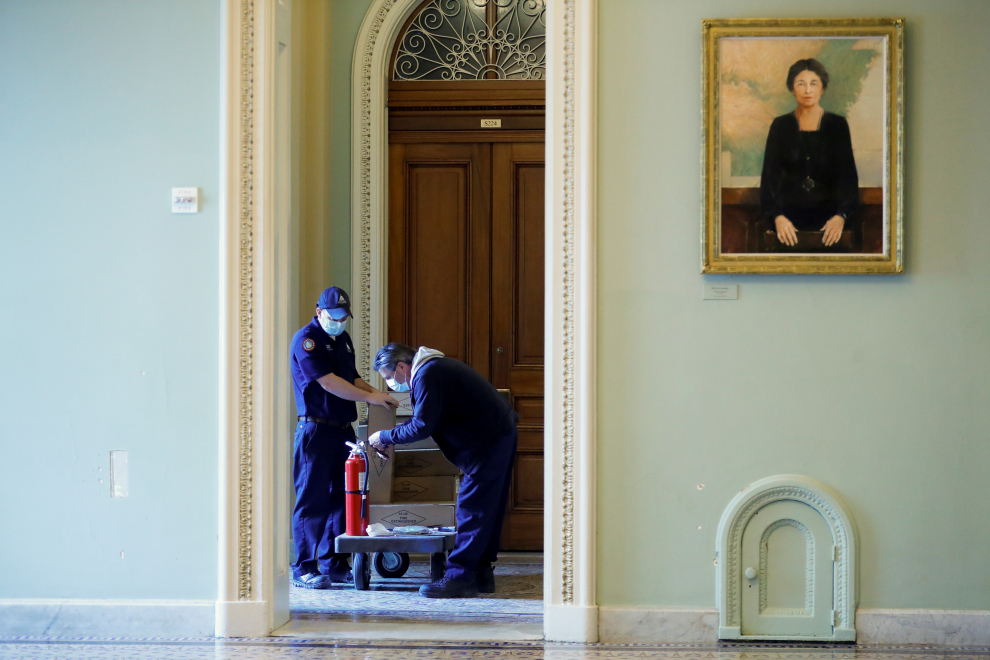 Empleados del Capitolio reabastecen extintores robados dentro del Capitolio de los Estados Unidos durante el motín.
