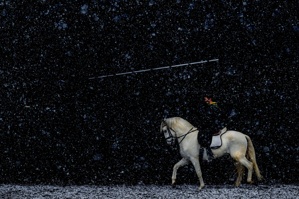 Un hombre monta a caballo en el centro hípico Soto del Grillo durante una nevada este jueves en Madrid.