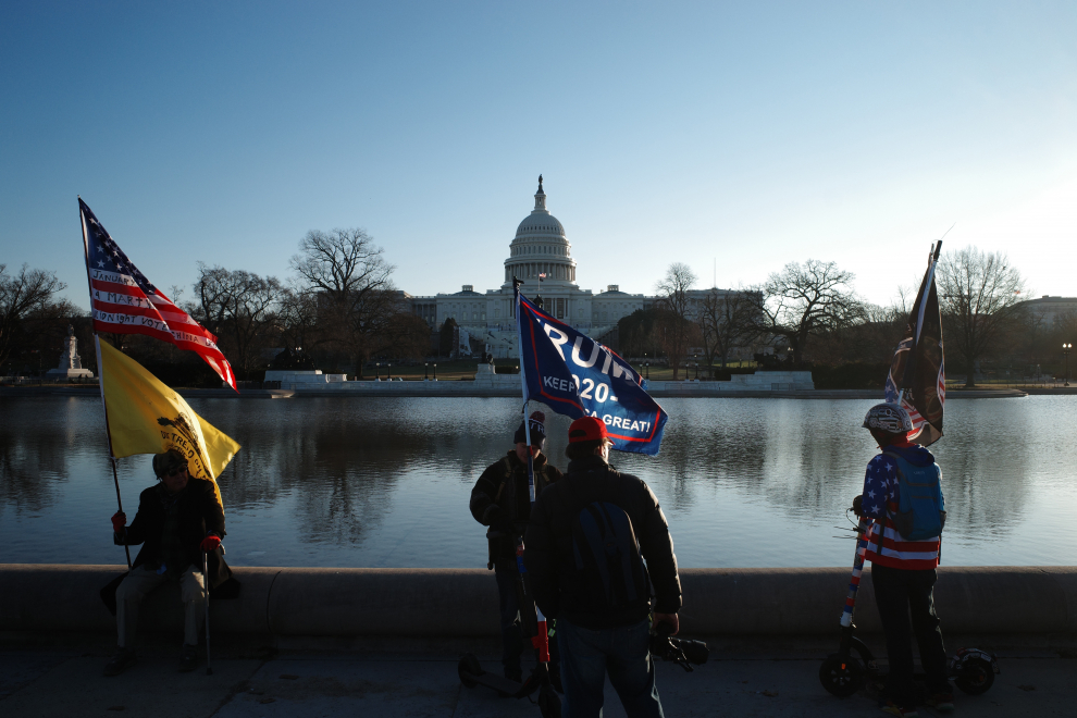 Algunos simpatizantes del presidente de Estados Unidos, Donald J. Trump, se reúnen junto al estanque del Capitolio de Estados Unidos un día después de las protestas.