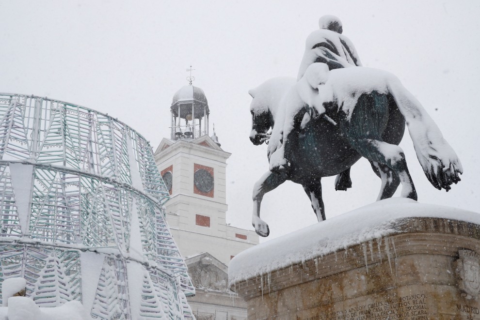 La estatua de Carlos III cubierta de nieve en la Puerta del Sol