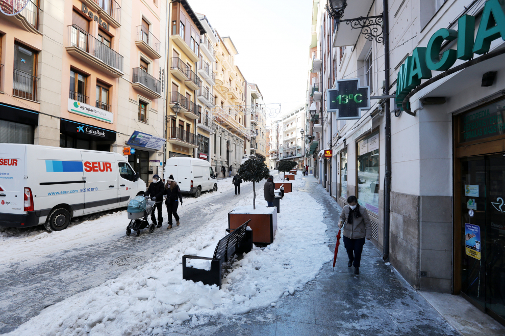 Transeúntes caminan al lado de un termómetro que marca -13 grados centígrados en el centro de la ciudad.