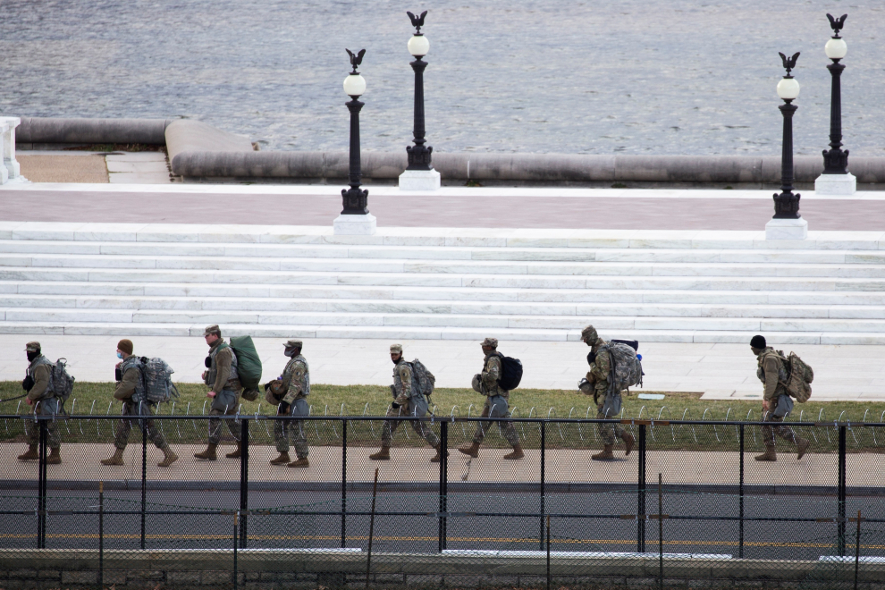 Miembros de la Guardia Nacional caminan cerca Capitolio mientras continúan los preparativos para la toma de posesión de Joe Biden como el 46 ° presidente de los Estados Unidos.