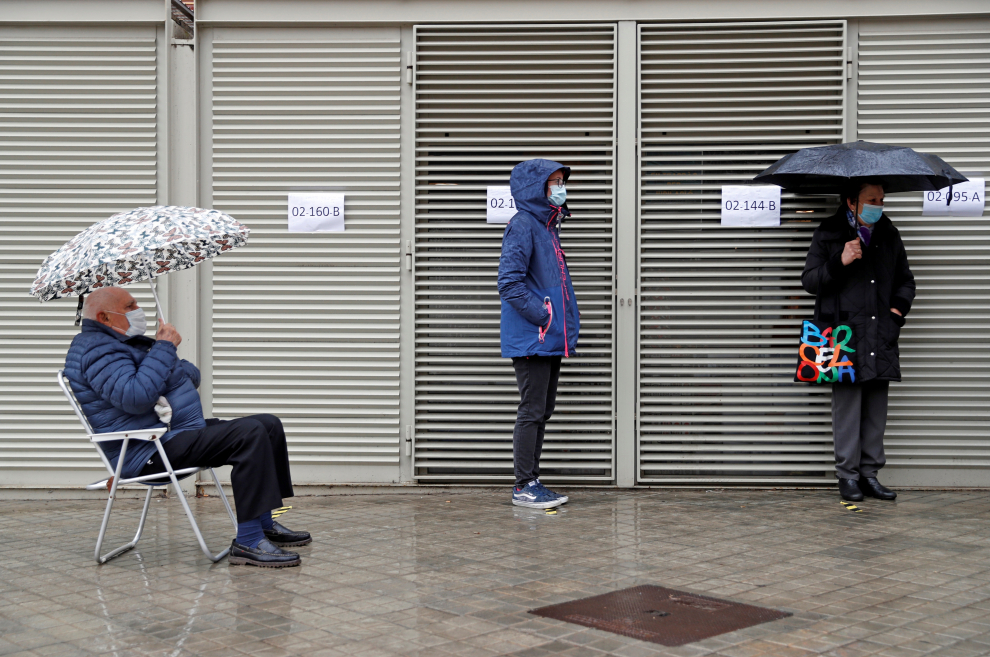 Varios votantes hacen cola en uno de los colegios electorales del Mercat de Sant Antoni de Barcelona a primera hora de este domingo.