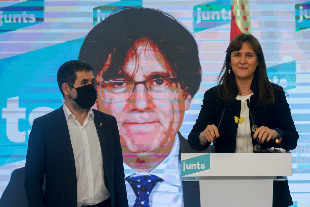 La candidata de JxCat a la presidencia de la Generalitat, Laura Borràs, acompañada por el secretario general del partido, Jordi Sánchez, con el ex presidente Carles Puigdemont por videoconferencia.