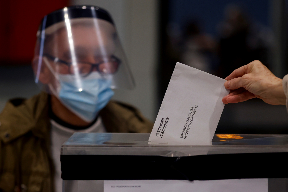 Una persona deposita su voto en el polideportivo Can Ricart del barrio del Raval de Barcelona hoy, domingo, cuando Cataluña