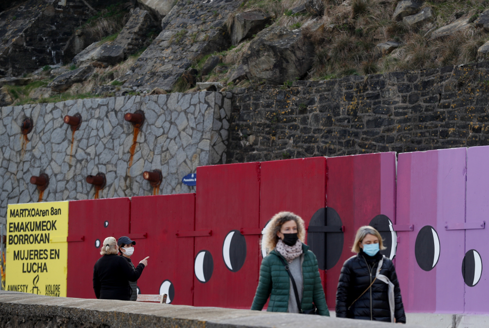 arias personas pasan junto a un mural de 34 por 2 metros diseñado por el escultor Koldobika Jauregi en el Paseo Nuevo de San Sebastián en conmemoración del 8M.