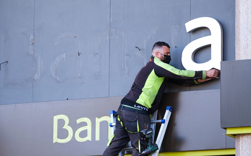 Los operarios desmontan el rótulo de Bankia de la sede principal del banco en Logroño.