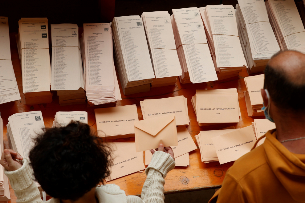 Vecinos de Moralzarzal (Madrid) hacen cola para votar este martes en las elecciones autonómicas.