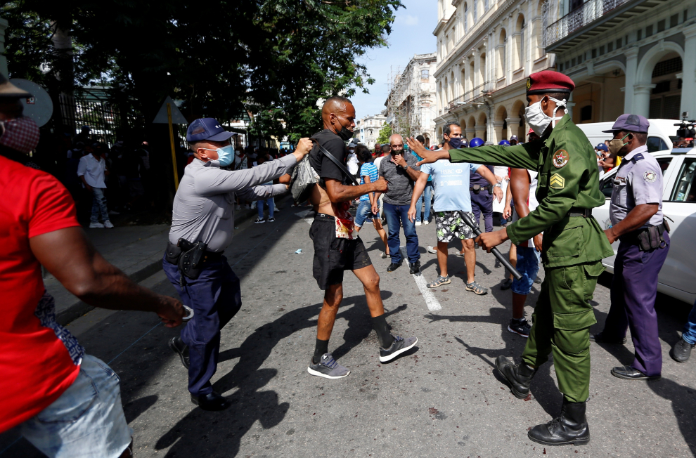 Un grupo de policías arresta a un participante de la marcha herido tras la protesta.