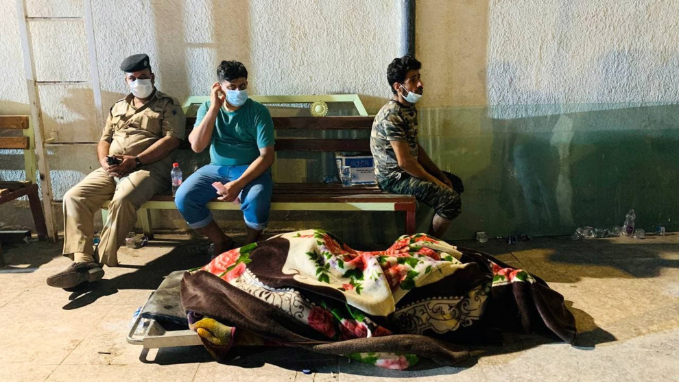 Familiares de uno de los fallecidos en el incendio esperan en la morgue de Nasiriyah para poder llevarse el cuerpo.