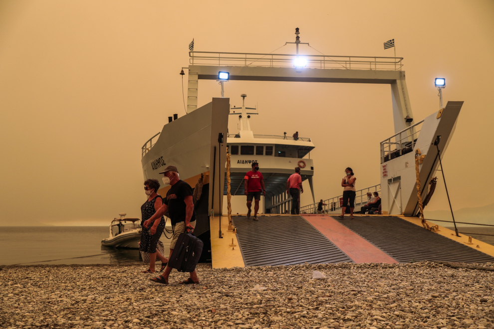 Un ferry atraca en la playa cerca del pueblo de Pefki para trasladar a los turistas y residentes a un lugar seguro debido a los incendios forestales.