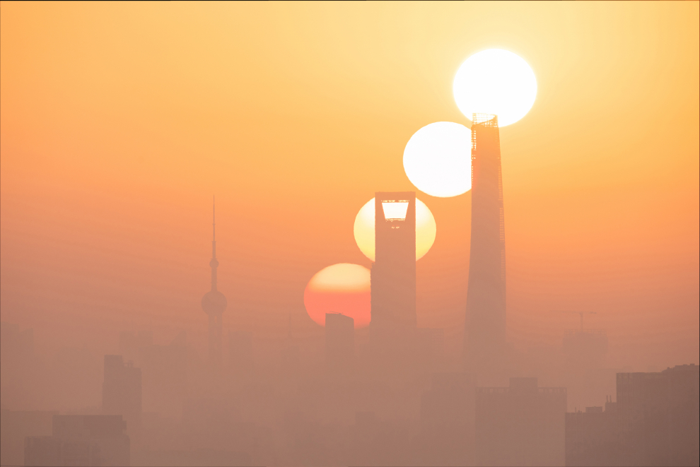 Shanghai es una de las ciudades más desarrolladas económicamente de China. La foto está tomada a 16 kilómetros del distrito financiero de Lujiazui. Cada año, solo hay unas pocas semanas en las que los fotógrafos pueden capturar la escena del sol saliendo en el Distrito Central de Negocios (CBD). El fotógrafo esperó unos días y finalmente fue testigo de la salida del sol desde la zona más próspera de Shanghai en una mañana muy contaminada. Shanghai, China, 7 de febrero de 2021