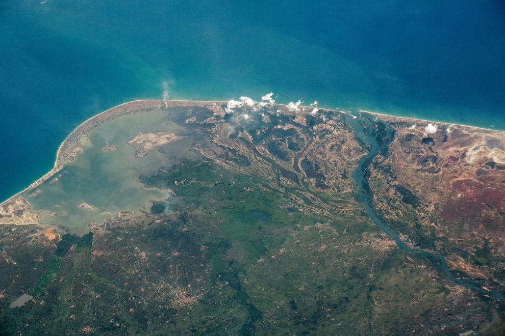Desde la órbita terrestre baja, un astronauta miró hacia el sur desde la Estación Espacial Internacional y tomó esta fotografía de la costa de Ghana. La imagen muestra el delta del río Volta, con un banco de arena suave que cierra la laguna Keta del golfo de Guinea. Los canales distribuidos del delta muestran que el río Volta solía desembocar en la laguna. Tomada el 26 de diciembre de 2020
