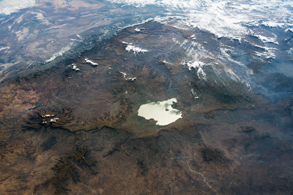 Mientras estaba en órbita sobre el centro de Sudán, un astronauta de la Estación Espacial Internacional tomó esta fotografía del lago Tana y las tierras altas de Etiopía. El ángulo oblicuo y las sombras ayudan a enfatizar el terreno accidentado de la meseta etíope, mientras que el lago Tana , el lago más grande de Etiopía, parece un espejo debido a la luz solar.