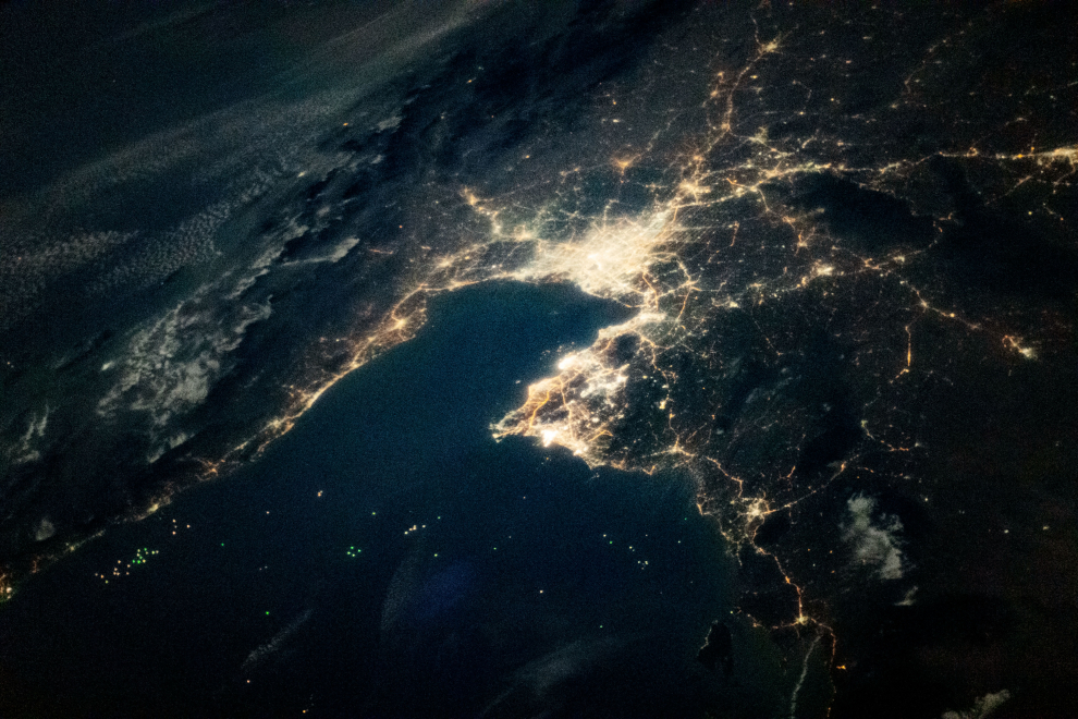 Esta fotografía oblicua captura la perspectiva de Tailandia vista de noche desde la Estación Espacial Internacional. Las luces más brillantes provienen de Bangkok, capital de Tailandia, junto a otras ciudades alineadas en la costa del Golfo de Tailandia. La franja oscura de tierra en la parte superior izquierda es la península de Malasia. Tomada el 26 de febrero de 2021