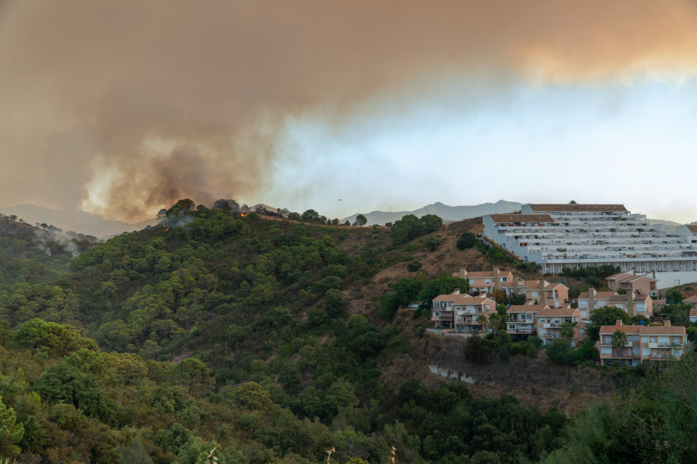 Vista de la urbanización Montesol en el término municipal de Estepona (Málaga), donde el Infoca lucha con medios aéreos medios contra el fuego forestal declarado en Sierra Bermeja.