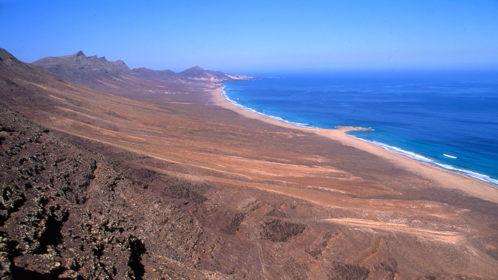 En una zona virgen al sur de la isla canaria de Fuerteventura encontramos esta playa con casi 14 kilómetros de longitud rodeada de montañas. Alejada de centros turísticos es perfecta para desconectar.