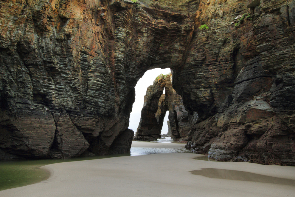 A 15 kilómetros de Ribadeo se encuentra esta monumental playa con arbotantes de 30 metros de altura, arcos dentro de otros arcos que puedes recorrer por  pasillos de arena entre muros de pizarra cuando baja la marea.