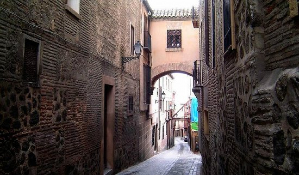 En el barrio de la Judería de Toledo se encuentra esta calle de paredes lisas, pequeñas puertas y discretos ventanucos. Al final de la calle encontramos el arco de herradura conocido con el nombre de Arquillo del Judío.