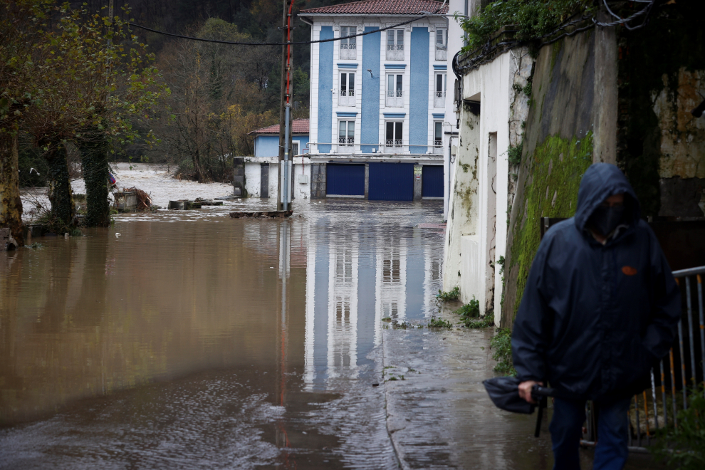 Un hombre camina junto al río Deba, desbordado a su paso por la localidad guipuzcoana de Mendaro. El Gobierno Vasco ha hecho un llamamiento a mantener la alerta y la tensión ante el temporal de lluvias en Euskadi.