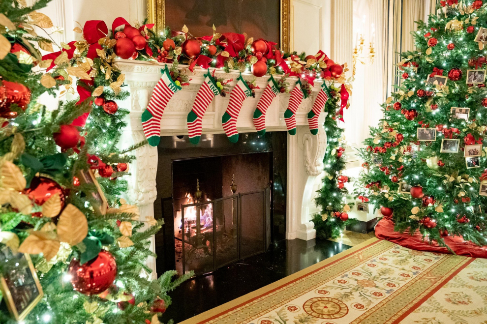 Calcetines en la chimenea, árboles llenos de adornos, la Navidad decora la Casa Blanca.