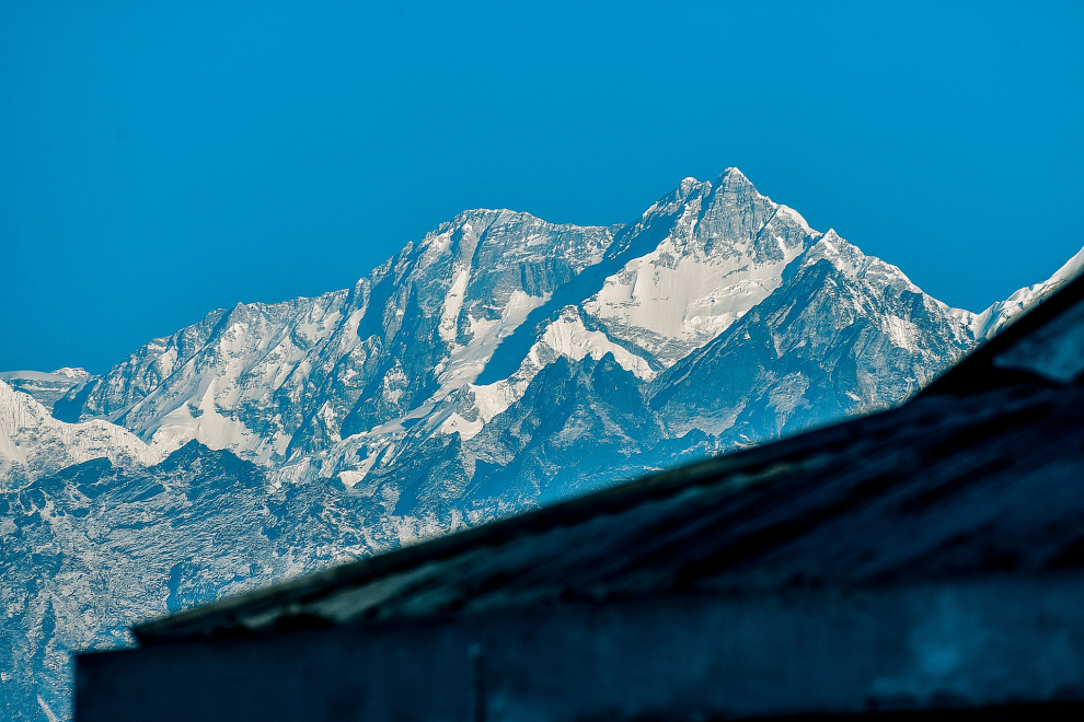 Su nombre se traduce como "Los cinco tesoros de las nieves", ya que la montaña tiene cinco picos, cuatro de ellos por encima de los 8.450 metros. Se encuentra entre India y Nepal. Los primeros coronar la cima fueron los ingleses George Band y Joe Brown el 25 de mayo de 1955.