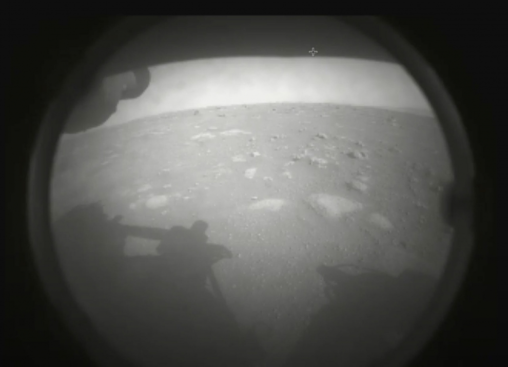 Esta es la primera imagen que envió el Rover Perseverance de la NASA después de aterrizar en Marte el 18 de febrero de 2021. La vista es desde una de las cámaras Hazard de Perseverance, está parcialmente oscurecida por una cubierta antipolvo.