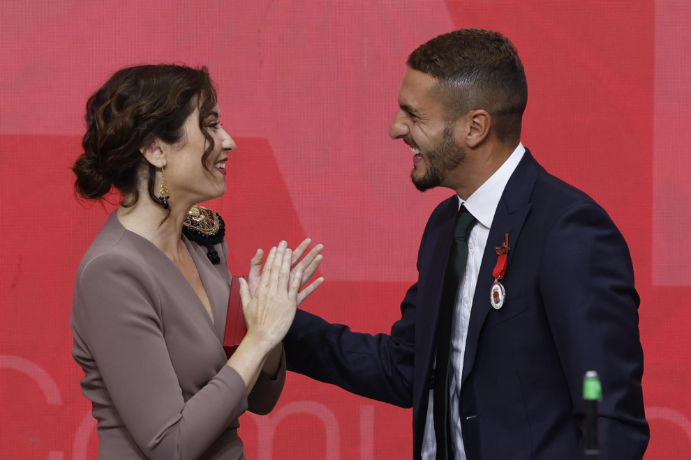 La presidenta de la Comunidad de Madrid, Isabel Díaz Ayuso (i), entrega la medalla de Plata de la Orden del Dos de Mayo al centrocampista del Atlético de Madrid Koke Resurrección.