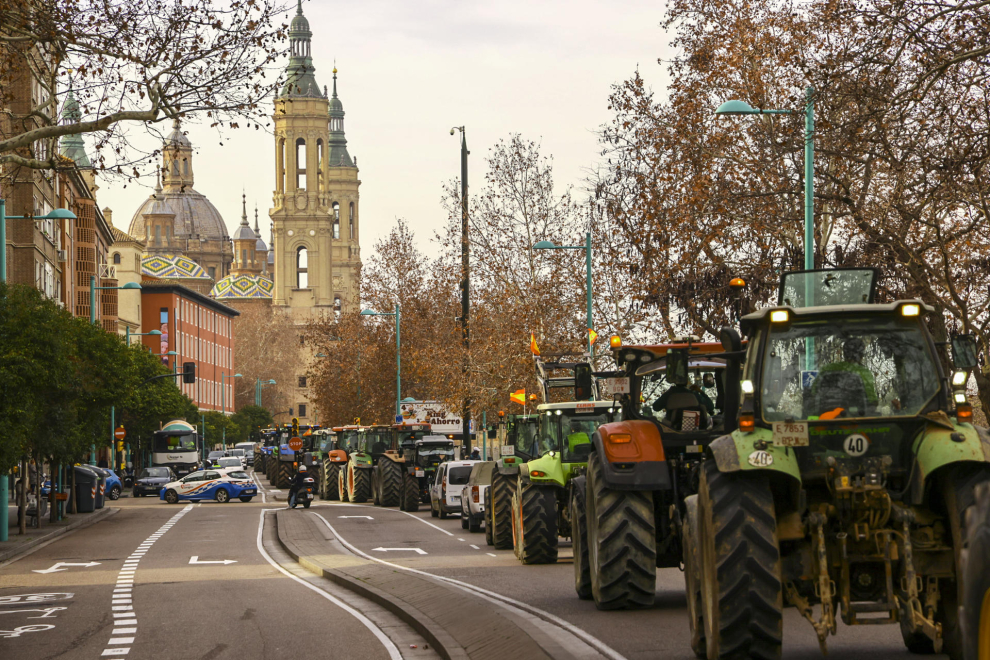 Agricultores con sus tractores marchan por las calles del centro de Zaragoza.