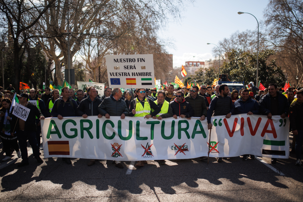Agricultores con una pancarta durante una manifestación en el Paseo del Prado hacia la Oficina de la Comisión Europea en Madrid.