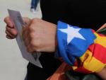 Una mujer acudiendo a votar a las pasadas elecciones del 27S en Cataluña, ataviada con una bandera 'estelada'./AFP