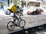 Trabajador de la empresa Glovo montando en bicicleta por Madrid