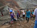 Voluntarios llevan el cuerpo de una víctima después de un deslizamiento de tierra en una mina de jade en Hpakant, Birmania